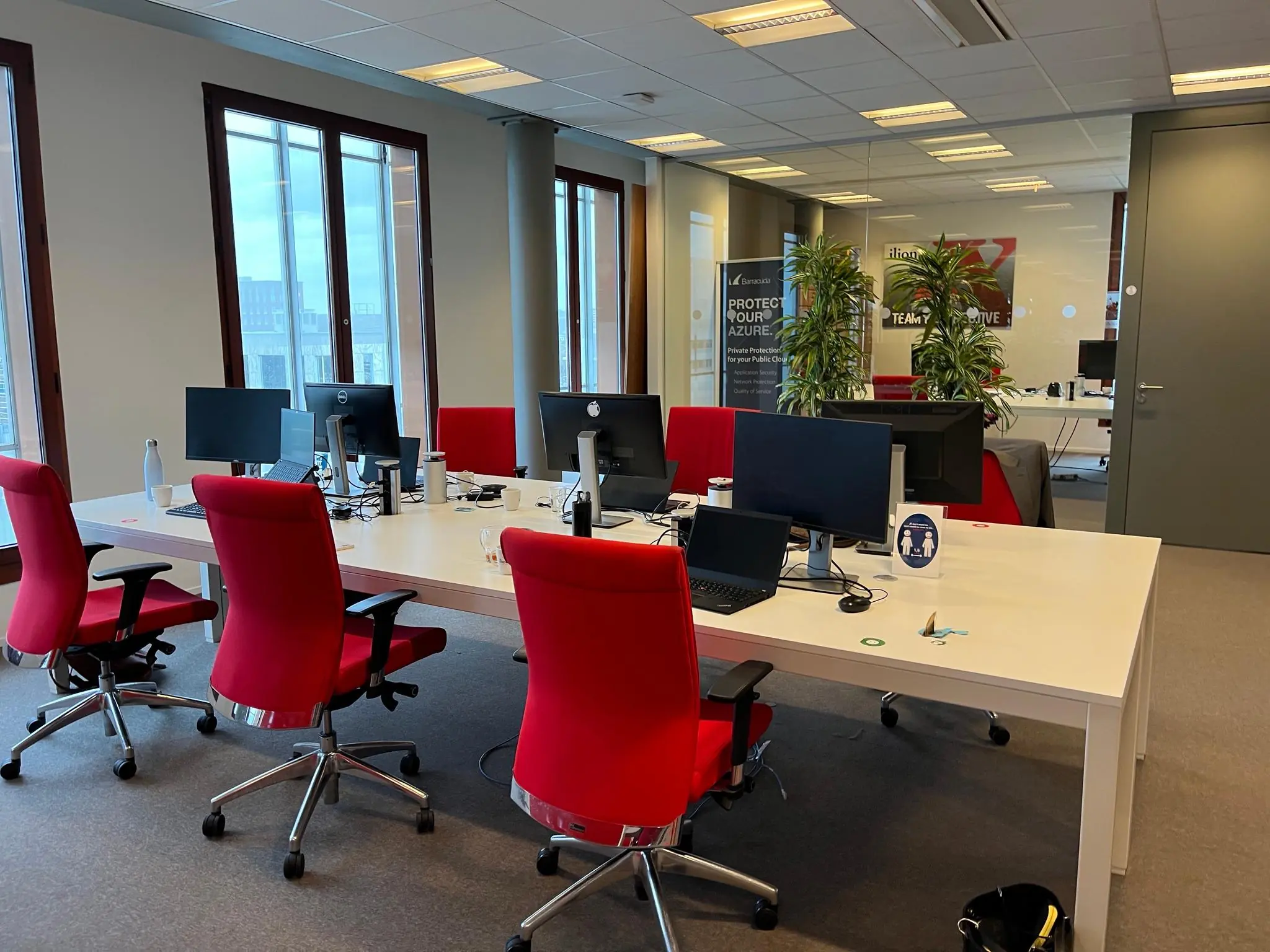 Modern kantoor met rode bureaustoelen, computers en grote ramen aan de Hondiuslaan.