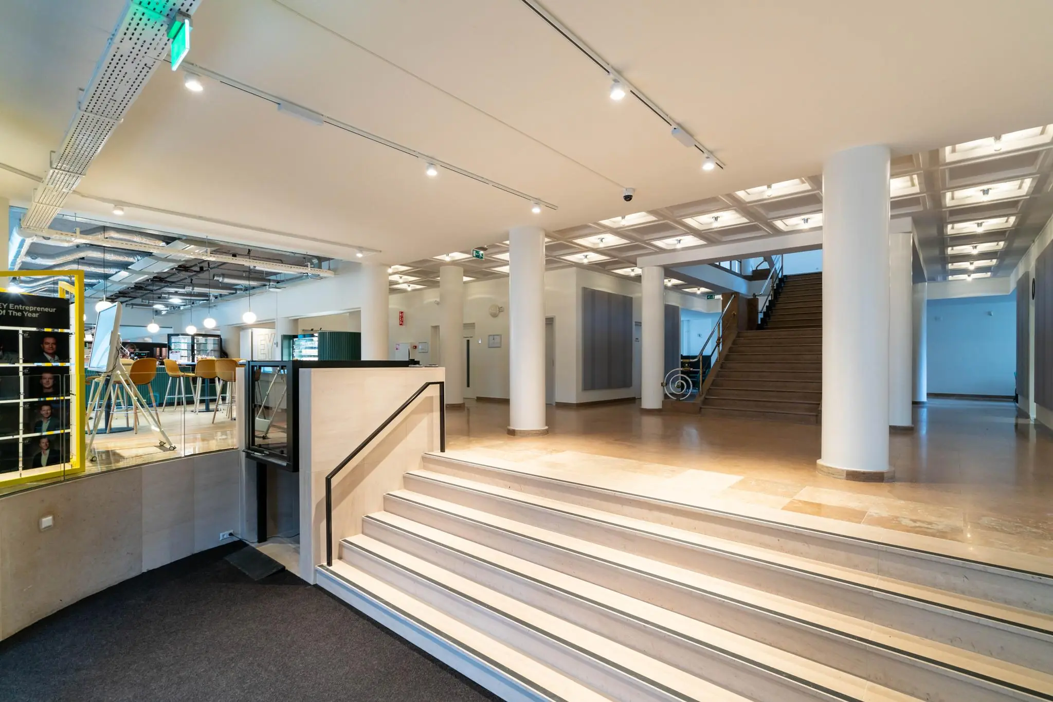 Moderne en lichte entreehal met brede trap, lift en uitzicht op een zithoek aan de Wassenaarseweg.