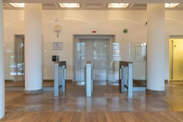 Entreehal met moderne toegangspoortjes en liften aan de Wassenaarseweg.