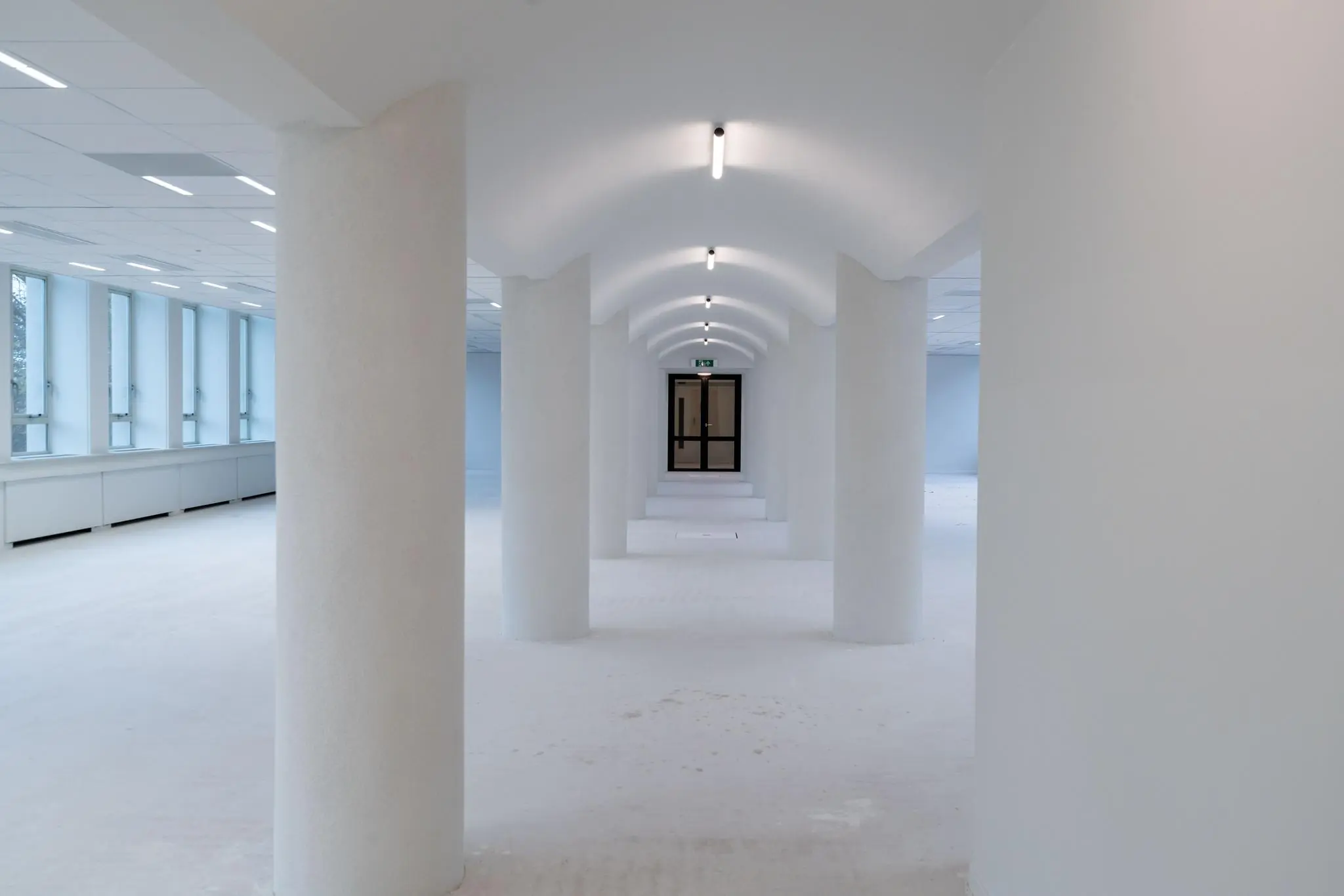 Licht en modern kantoorgebouw aan de Wassenaarseweg met witte zuilen en gewelfd plafond.