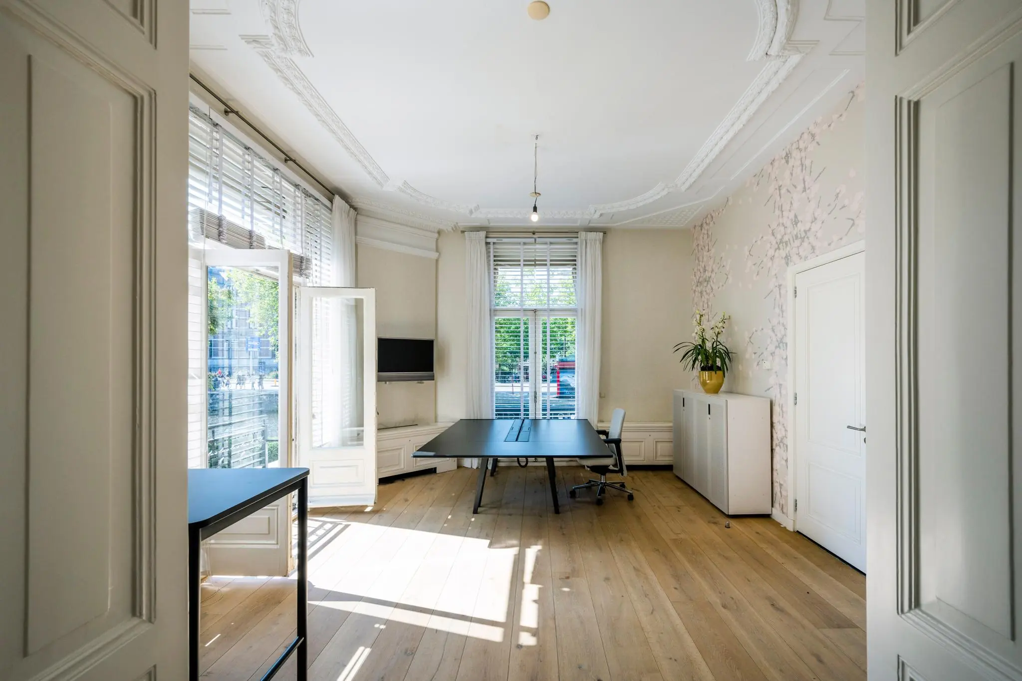 Licht en ruim kantoor aan de Weteringschans met grote ramen, houten vloer en moderne inrichting.