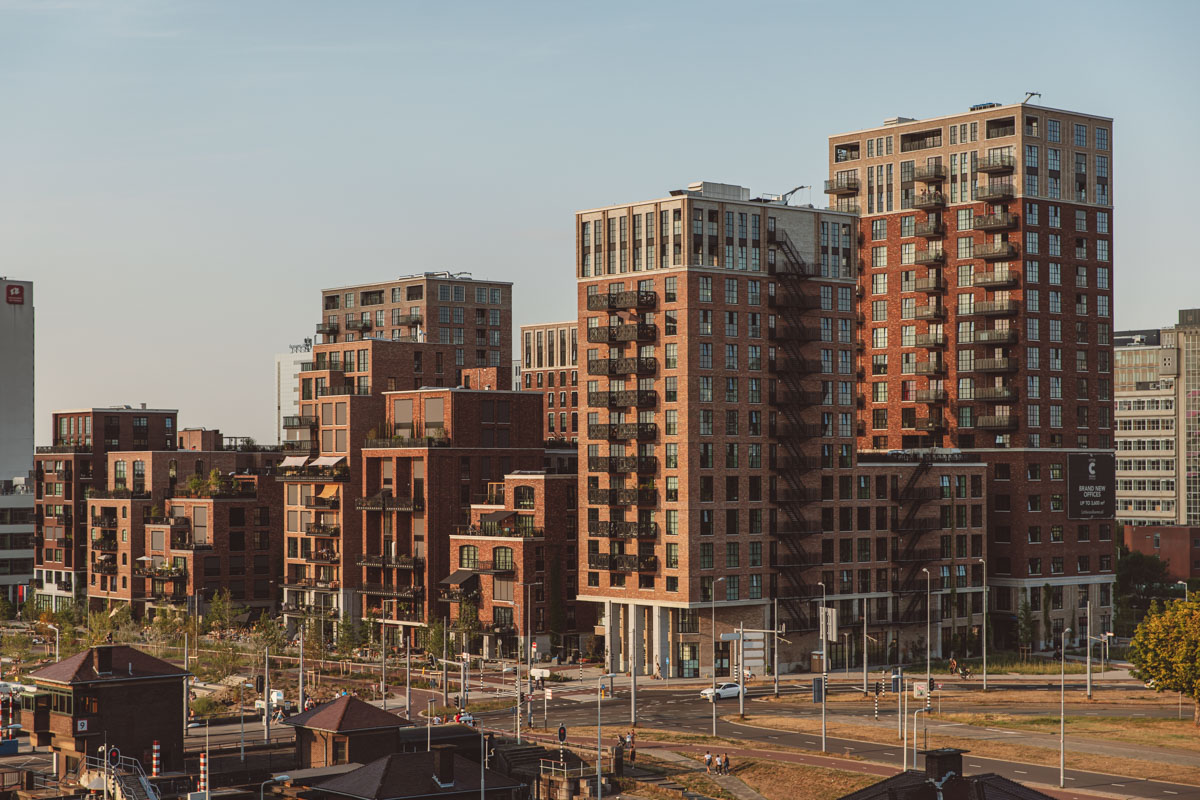 Rode bakstenen appartementencomplexen aan de Karl-Weisbardstraat bij zonsondergang.