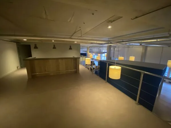 Bovenvloer van een modern kantoorpand aan de Lulofsstraat met een houten bar en hanglampen.