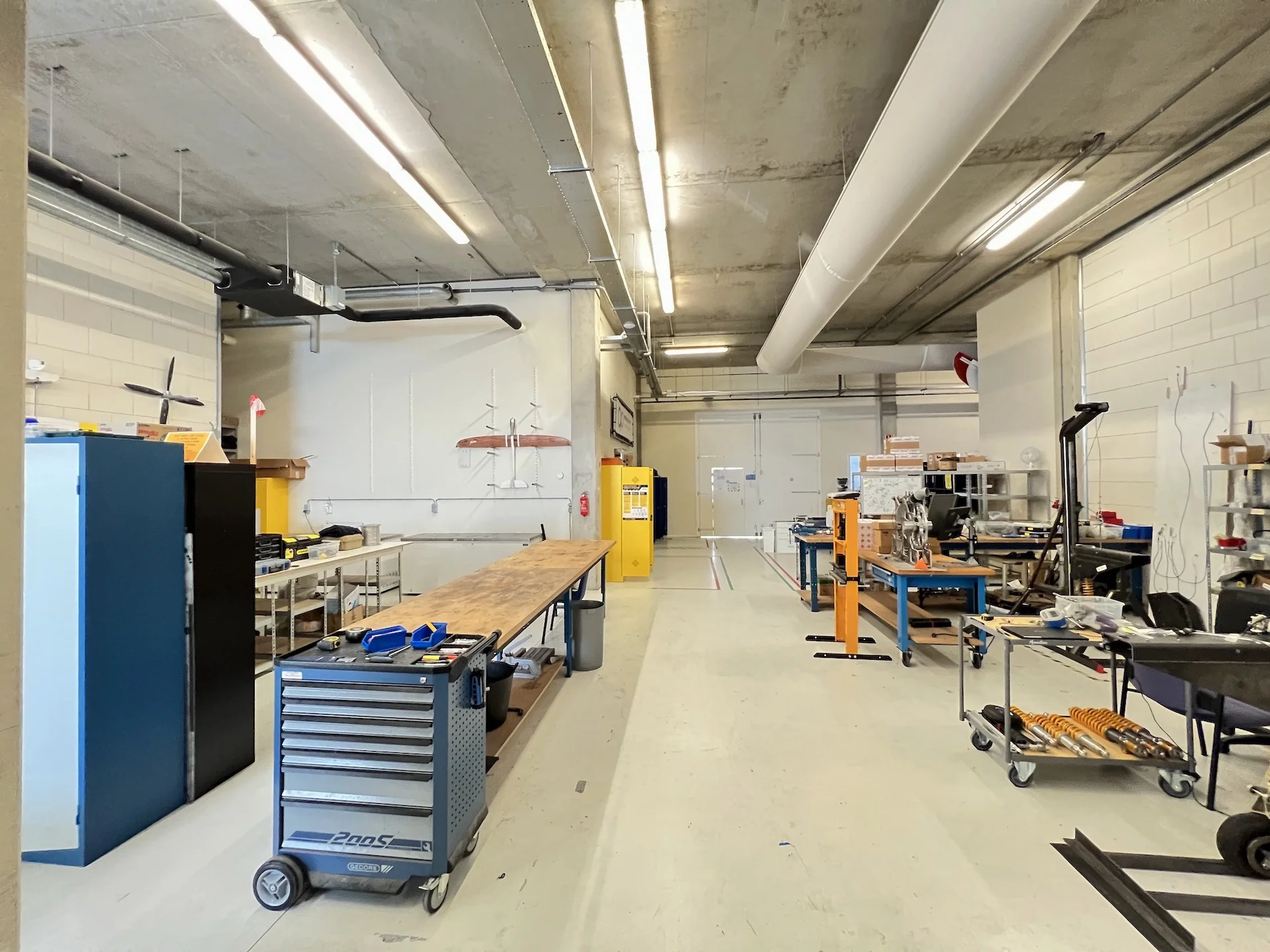 Werkruimte aan de Lulofsstraat met werkbanken, gereedschapswagens en technische apparatuur in een industriële setting.