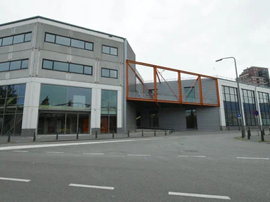Modern kantoorgebouw aan de Lulofsstraat met opvallende oranje loopbrug over de entree.