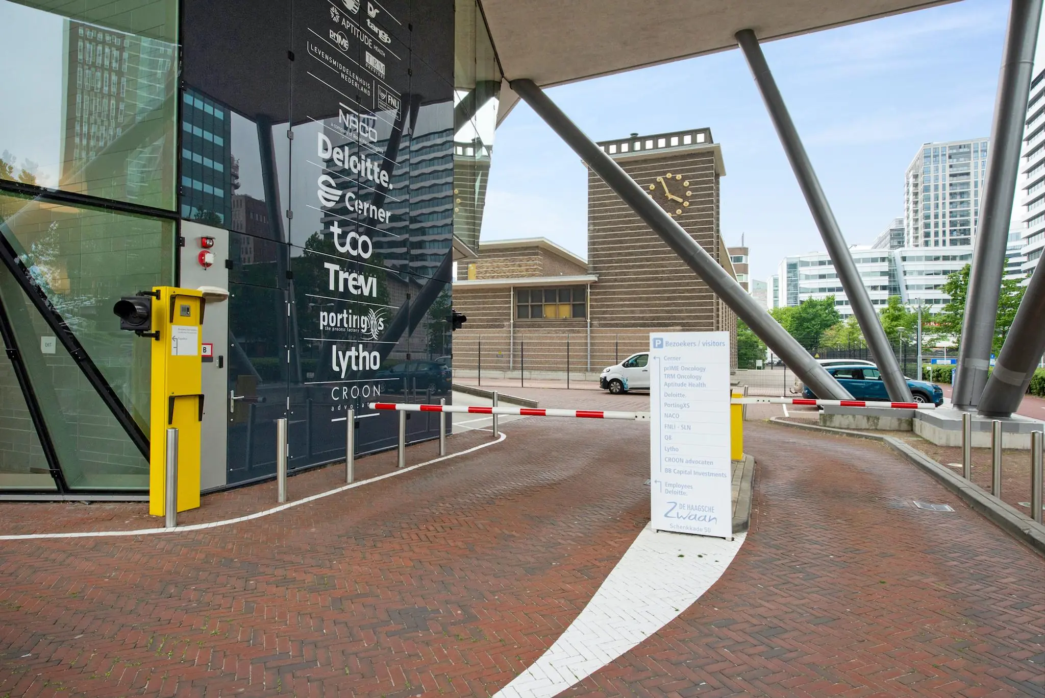 Ingang van parkeergarage bij kantoorgebouw De Haagsche Zwaan aan de Schenkkade met namen van gevestigde bedrijven op de gevel.