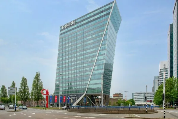 Modern kantoorgebouw van Deloitte aan de Schenkkade in Den Haag met een opvallend hellende architectuur.