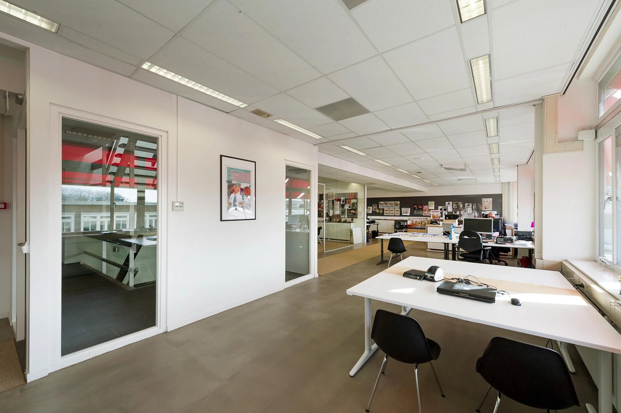 Modern kantoorinterieur aan de Helicopterstraat met open werkplekken en glazen wanden.