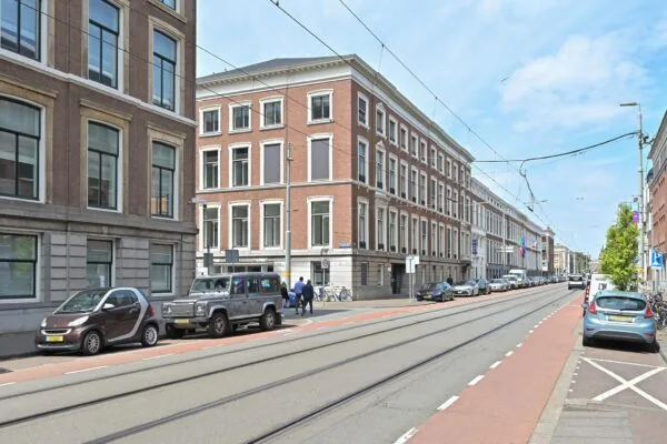 Straatbeeld van de Parkstraat in Den Haag met klassieke gevels, tramrails en geparkeerde auto's.