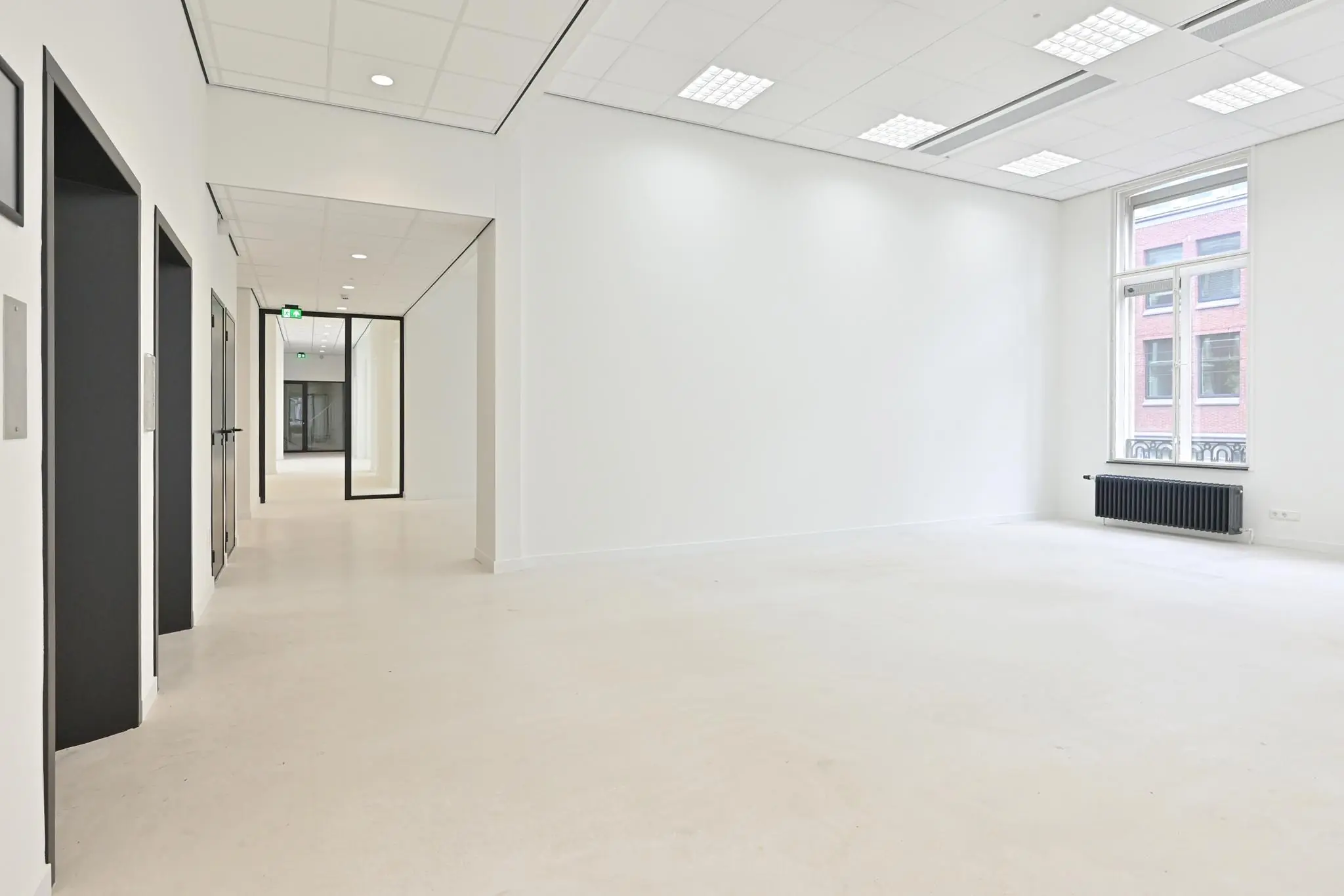 Licht en modern kantoorpand aan de Parkstraat met witte muren, systeemplafond en grote ramen.