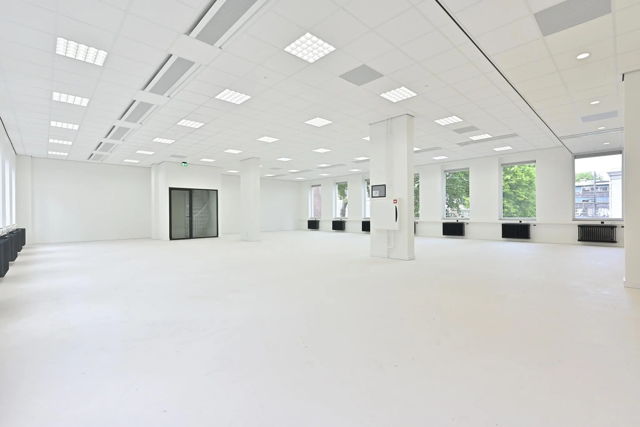 Lichte, open kantoorruimte aan de Parkstraat met grote ramen en systeemplafond.