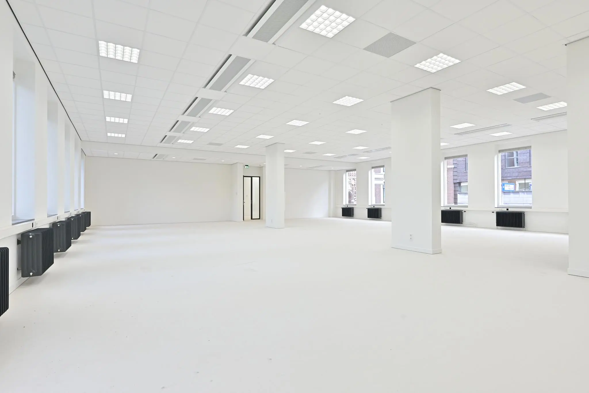 Licht en ruim leeg kantoorpand aan de Parkstraat met grote ramen en systeemplafond.
