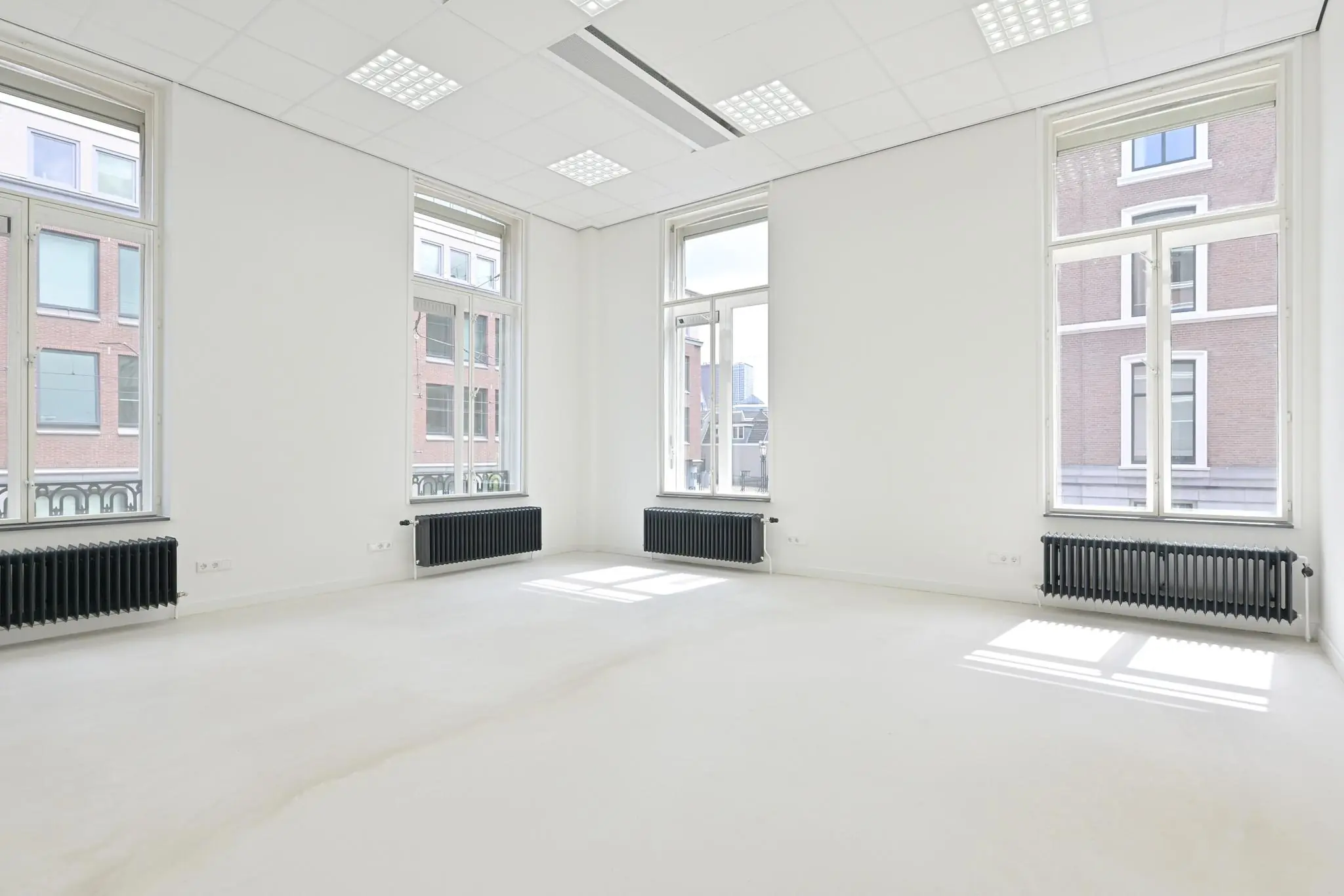 Licht en modern kantoorpand aan de Parkstraat met grote ramen en witte muren.