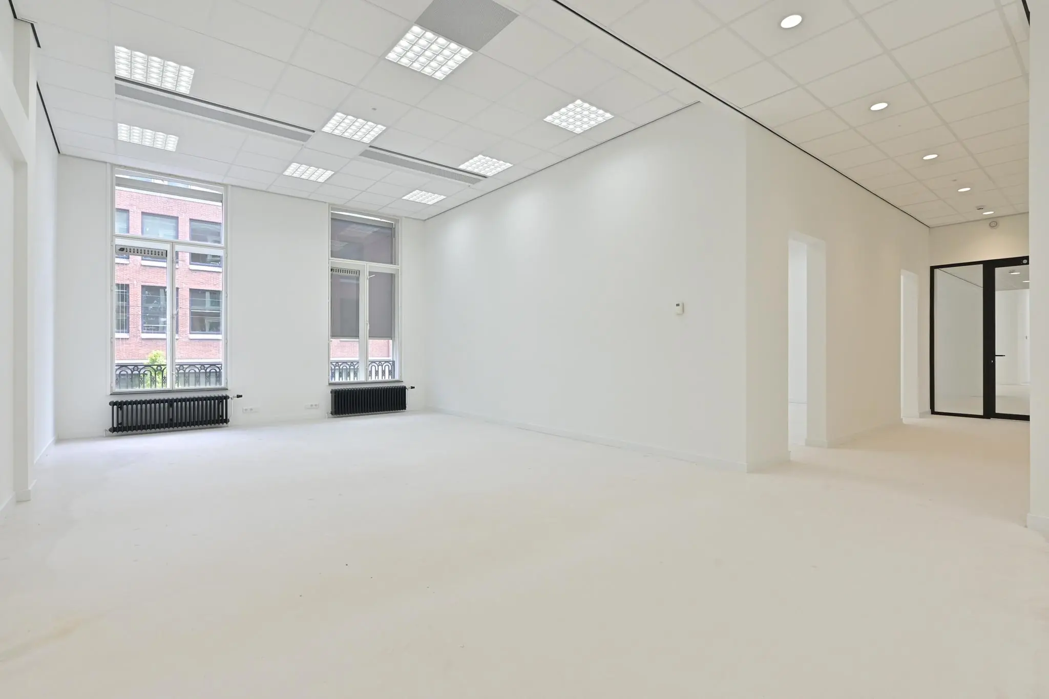 Licht en modern kantoorpand aan de Parkstraat met grote ramen, witte muren en systeemplafond.