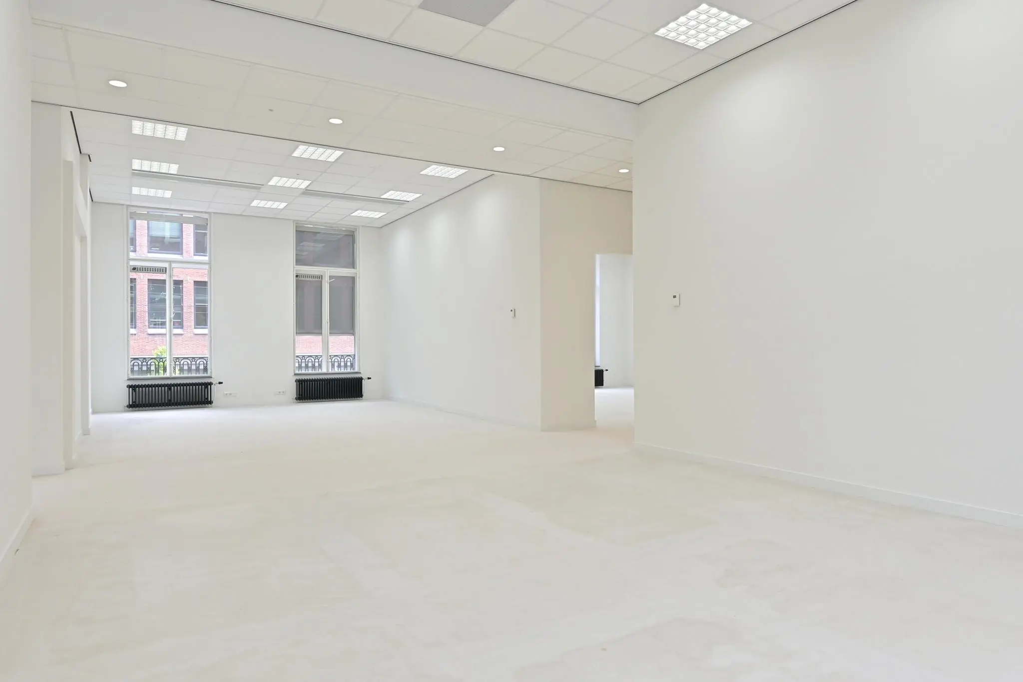 Lichte, lege kantoorruimte aan de Parkstraat met grote ramen en systeemplafond.