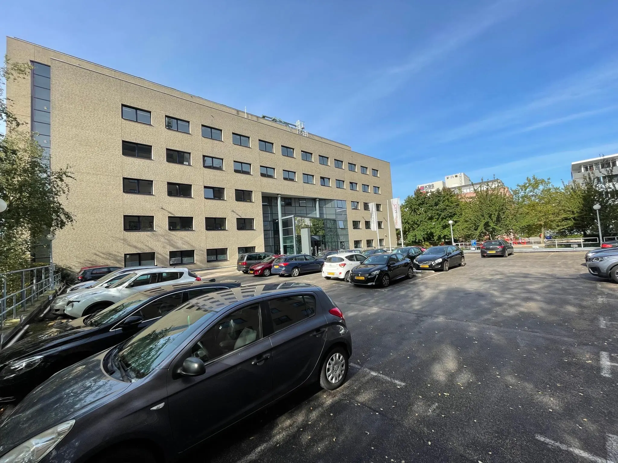 Kantoorgebouw aan de Euclideslaan met aangrenzende parkeerplaats op een zonnige dag.