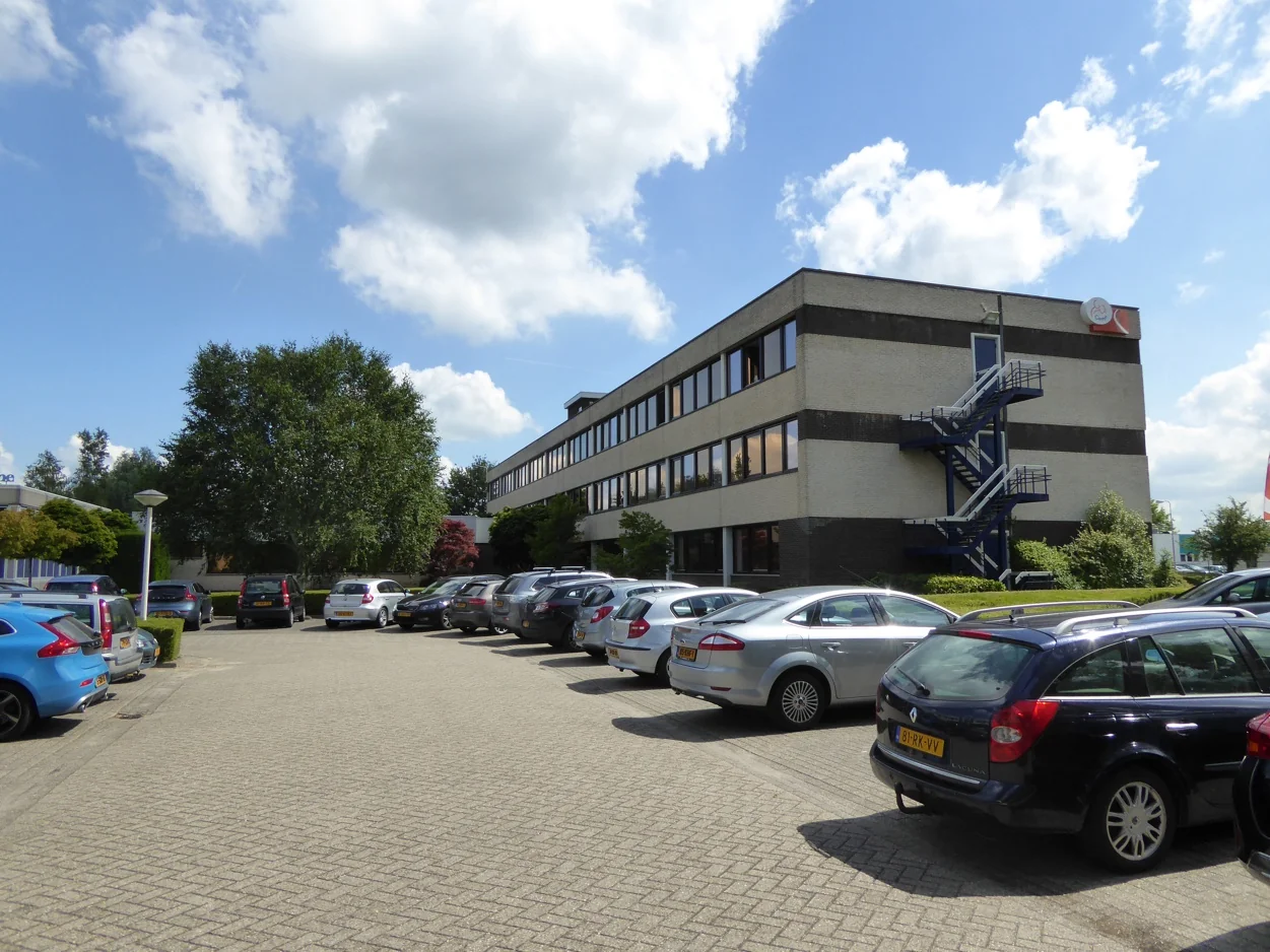 Kantoorgebouw aan de Maarssenbroeksedijk met parkeerplaats op de voorgrond en een externe trap aan de zijkant.