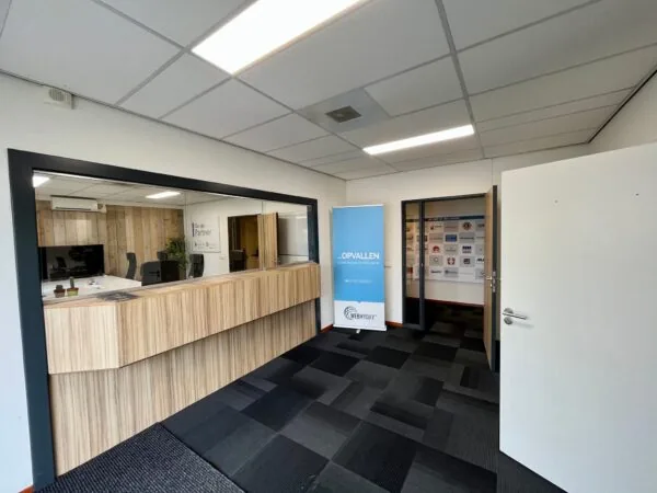 Moderne kantoorentree aan de Daltonstraat met houten balie, vergaderruimte en banner van Webmyday.