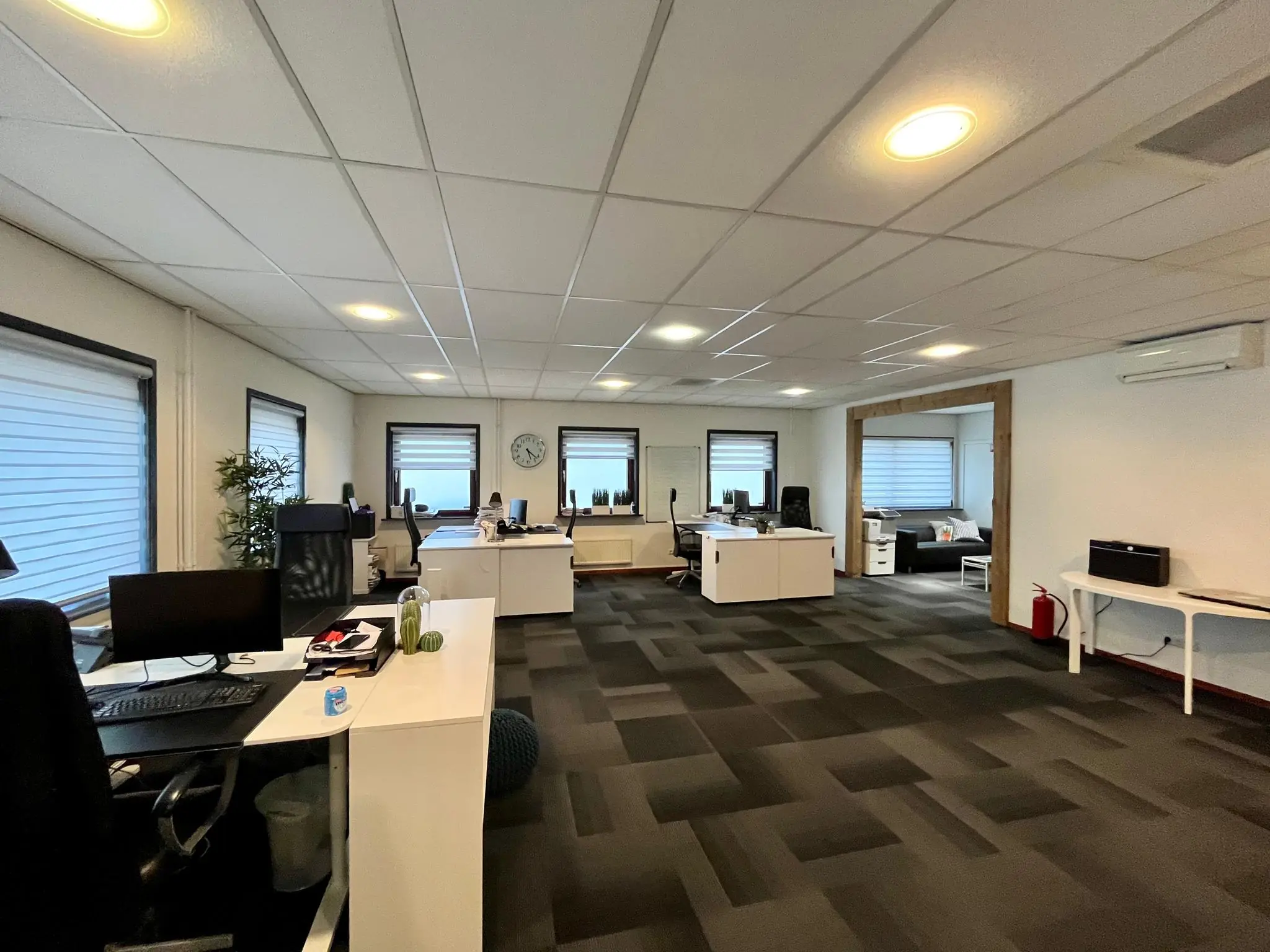 Modern kantoorinterieur aan de Daltonstraat met meerdere werkplekken, bureaus en een zithoek.