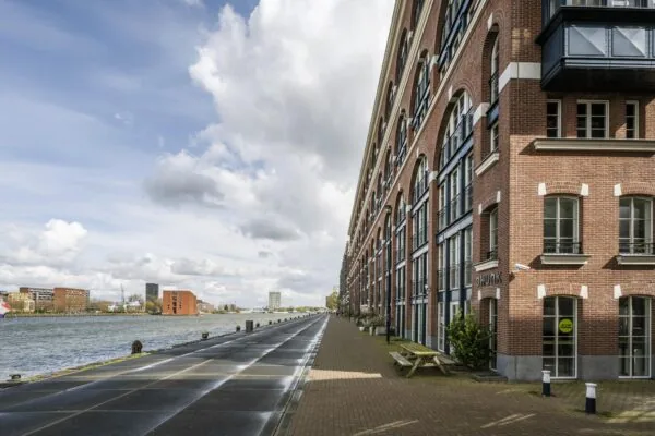 Bebouwde kade aan het water met historische bakstenen panden aan de Oostelijke Handelskade in Amsterdam.
