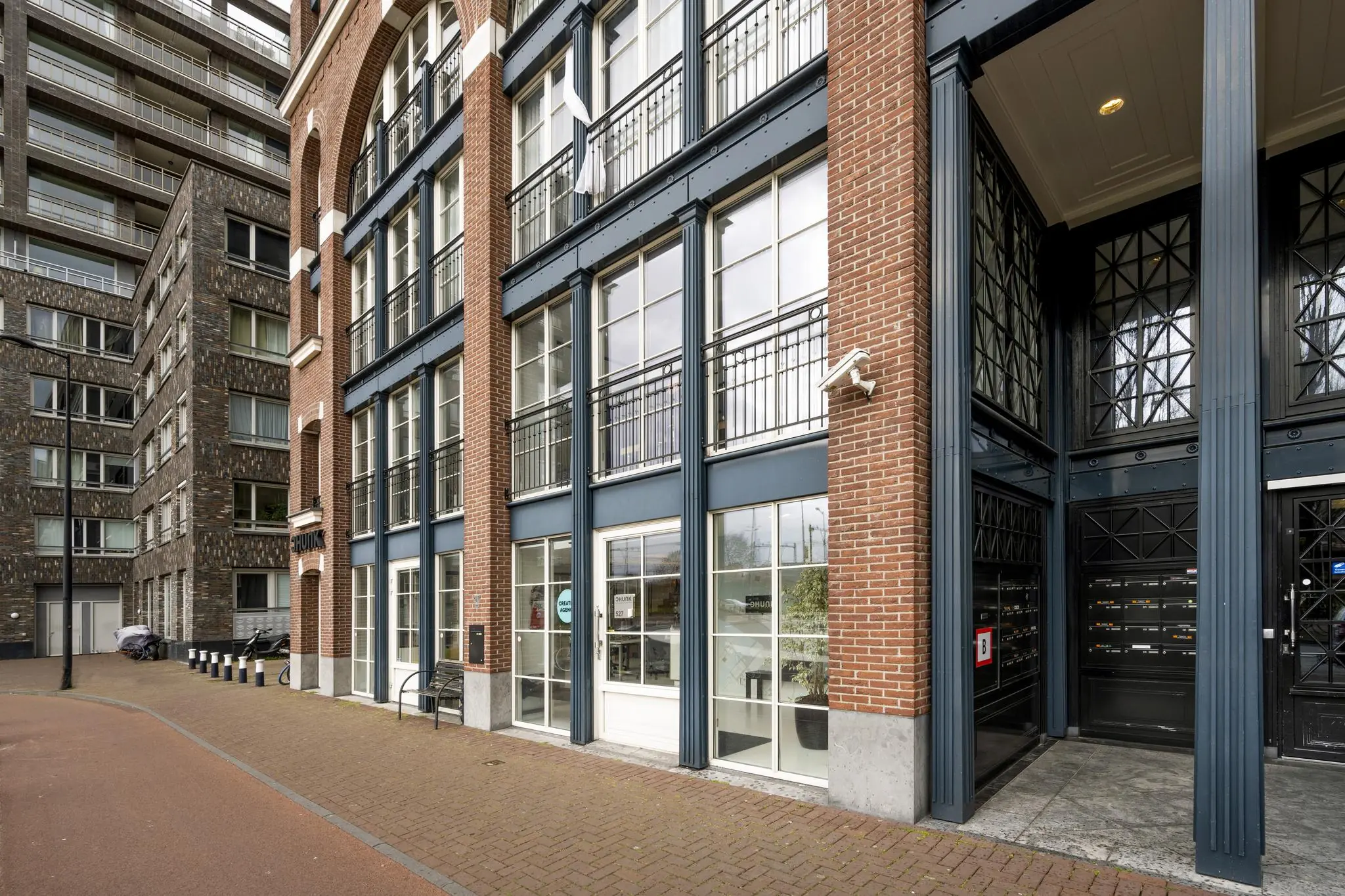 Moderne appartementen aan de Oostelijke Handelskade met een gevel van rood baksteen en grote ramen.