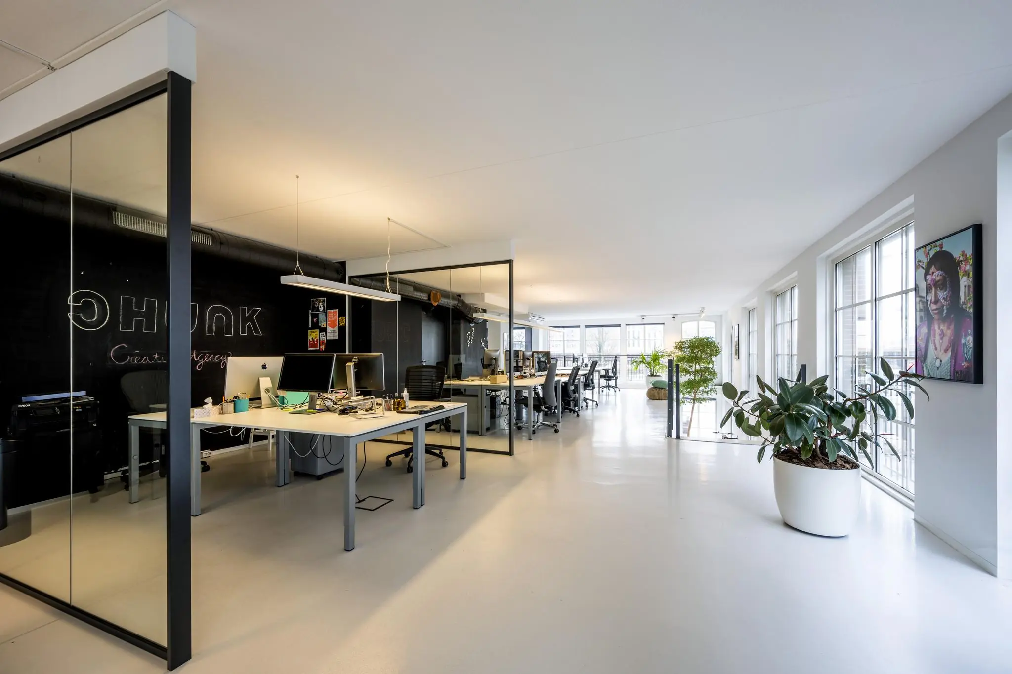 Modern kantoorinterieur aan de Oostelijke Handelskade met open werkplekken, glazen wanden en veel daglicht.