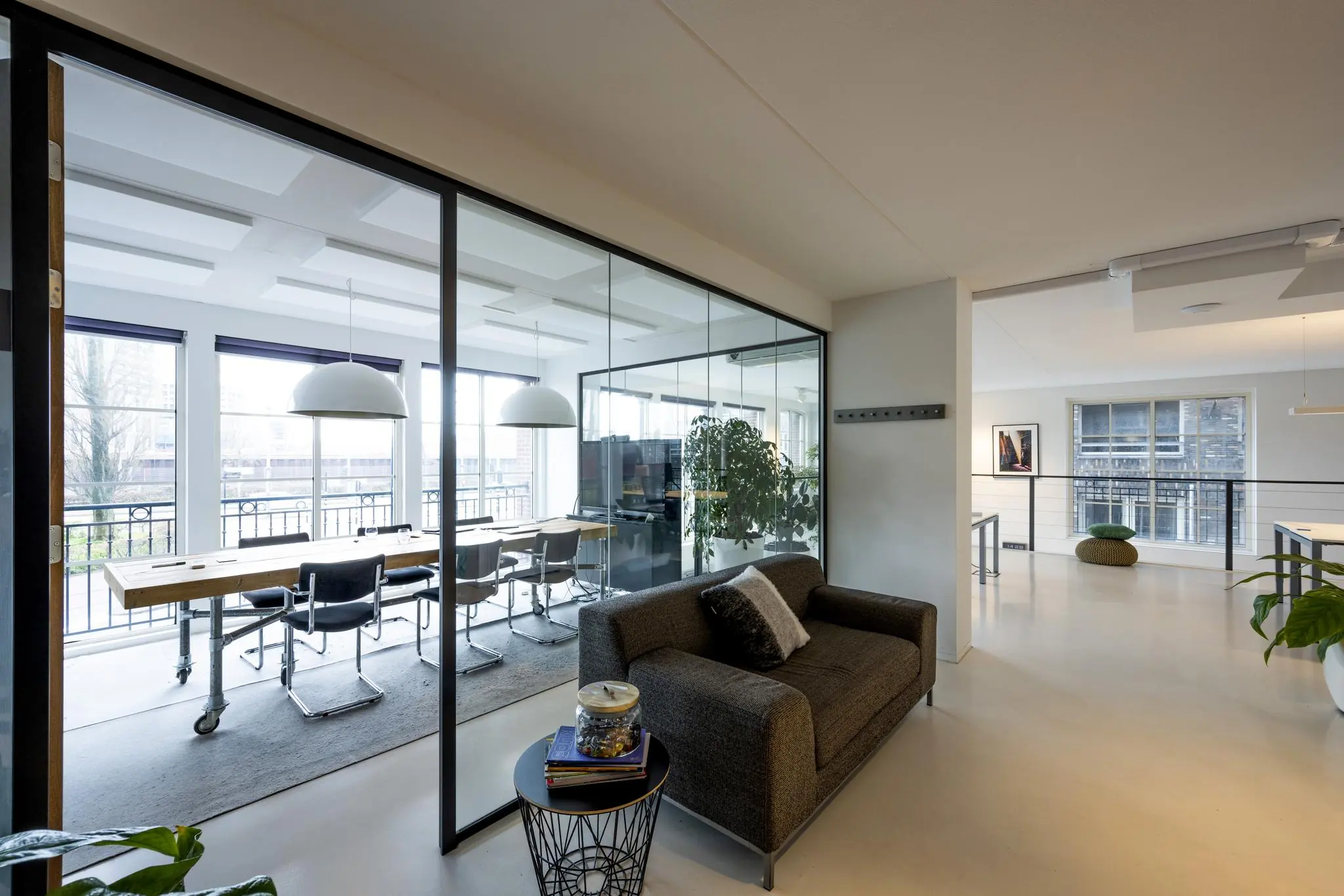 Modern kantoorinterieur aan de Oostelijke Handelskade met glazen vergaderruimte en zithoek.