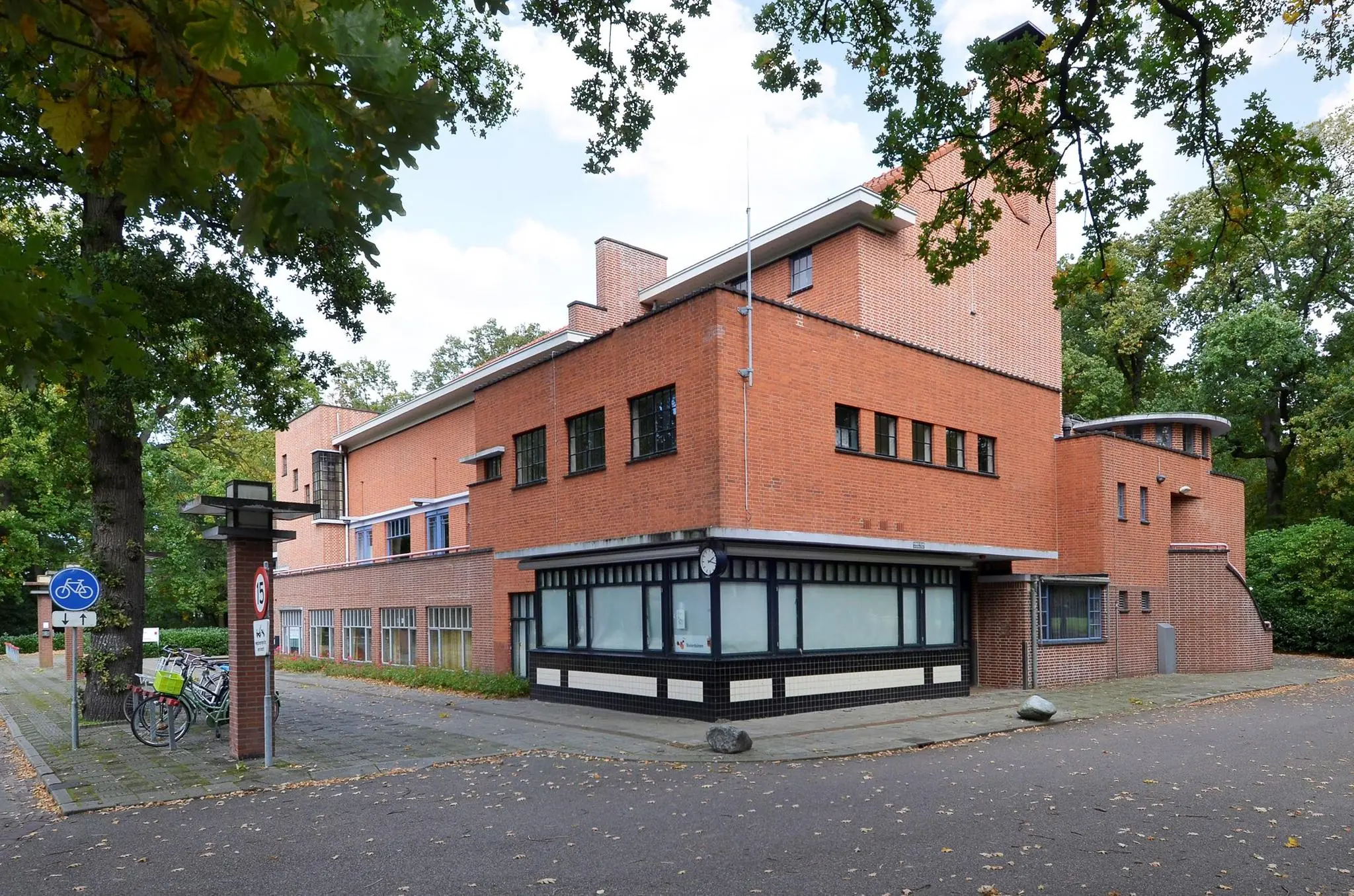 Bakstenen gebouw aan de Endegeesterstraatweg met een opvallende hoekstructuur en omliggende bomen.