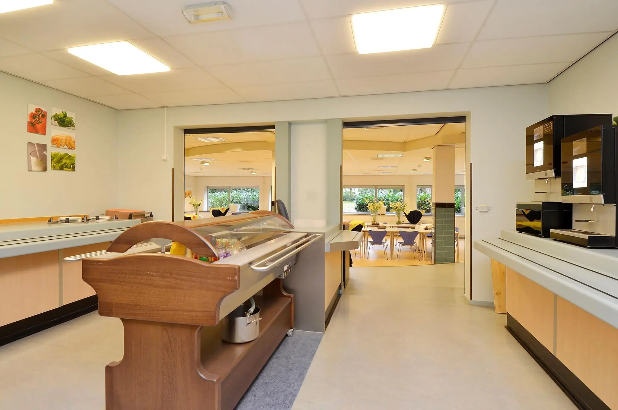 Eetruimte met buffet en koffieautomaten in een verzorgingsinstelling aan de Endegeesterstraatweg.