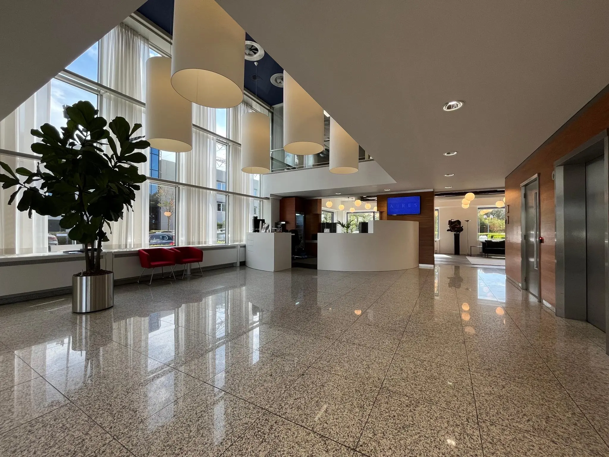 Moderne ontvangsthal aan de Savannahweg met grote ramen, hanglampen, een balie en zithoek.