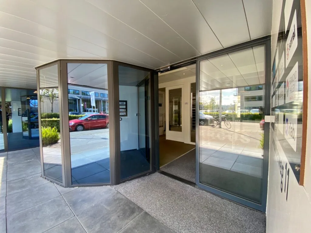 Ingang van een kantoorpand aan de Computerweg 11 met glazen deuren en bedrijfsnaambord.