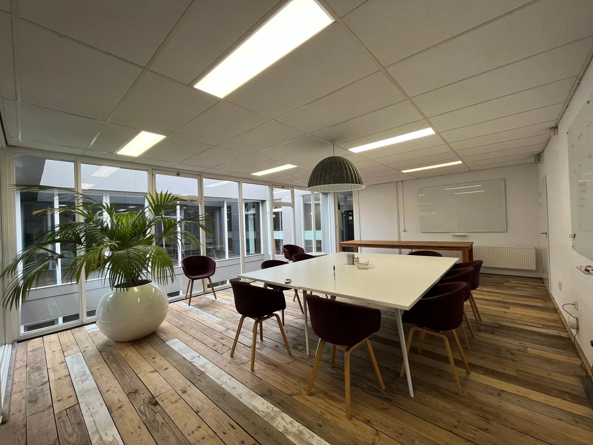 Moderne vergaderruimte aan de Computerweg met een grote tafel, designstoelen, houten vloer en veel natuurlijk licht.
