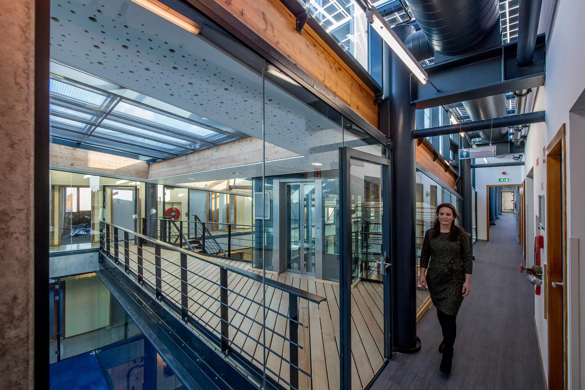 Vrouw loopt door moderne kantoorruimte in bedrijfsgebouw aan de Fokkerstraat.