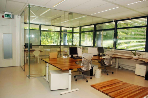 Modern kantoor met glazen wanden, houten bureaus en ergonomische bureaustoelen aan de Vreeswijksestraatweg.