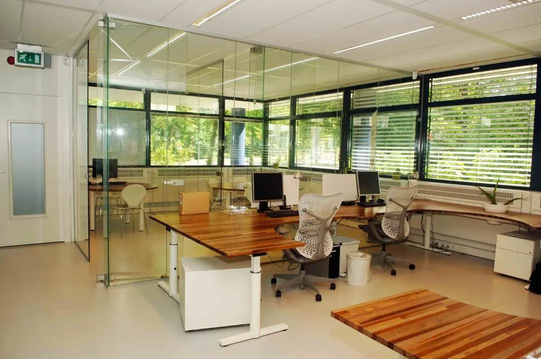 Modern kantoor met glazen wanden, houten bureaus en ergonomische bureaustoelen aan de Vreeswijksestraatweg.