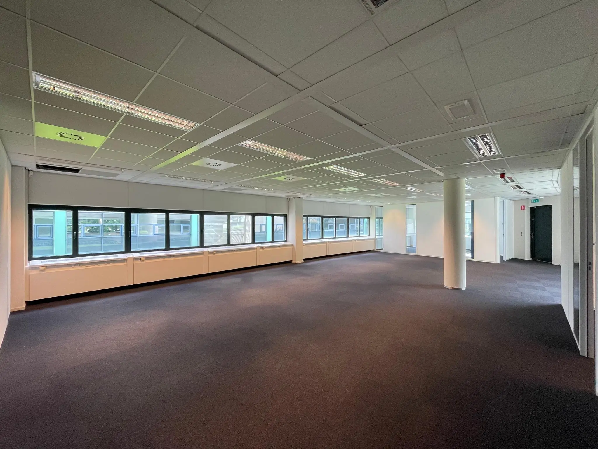Leeg, modern kantoorpand met raamwand aan de Sparrenheuvel.