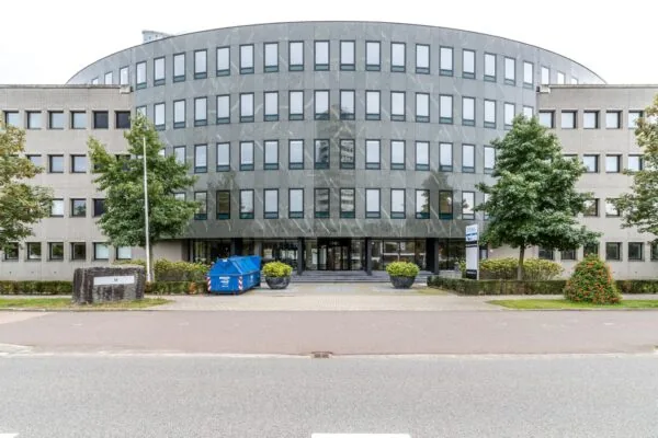 Kantoorgebouw aan de Pythagoraslaan met een moderne gevel en een blauwe afvalcontainer voor de ingang.