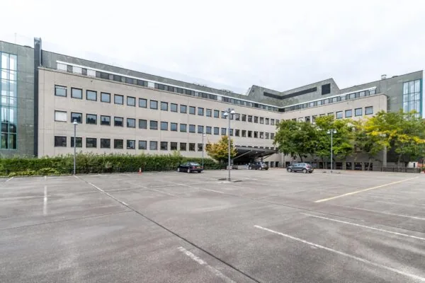 Kantoorgebouw aan de Pythagoraslaan met parkeerterrein op de voorgrond.