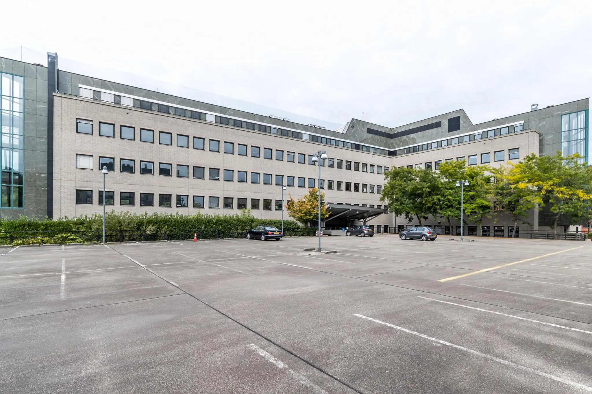 Kantoorgebouw aan de Pythagoraslaan met parkeerterrein op de voorgrond.