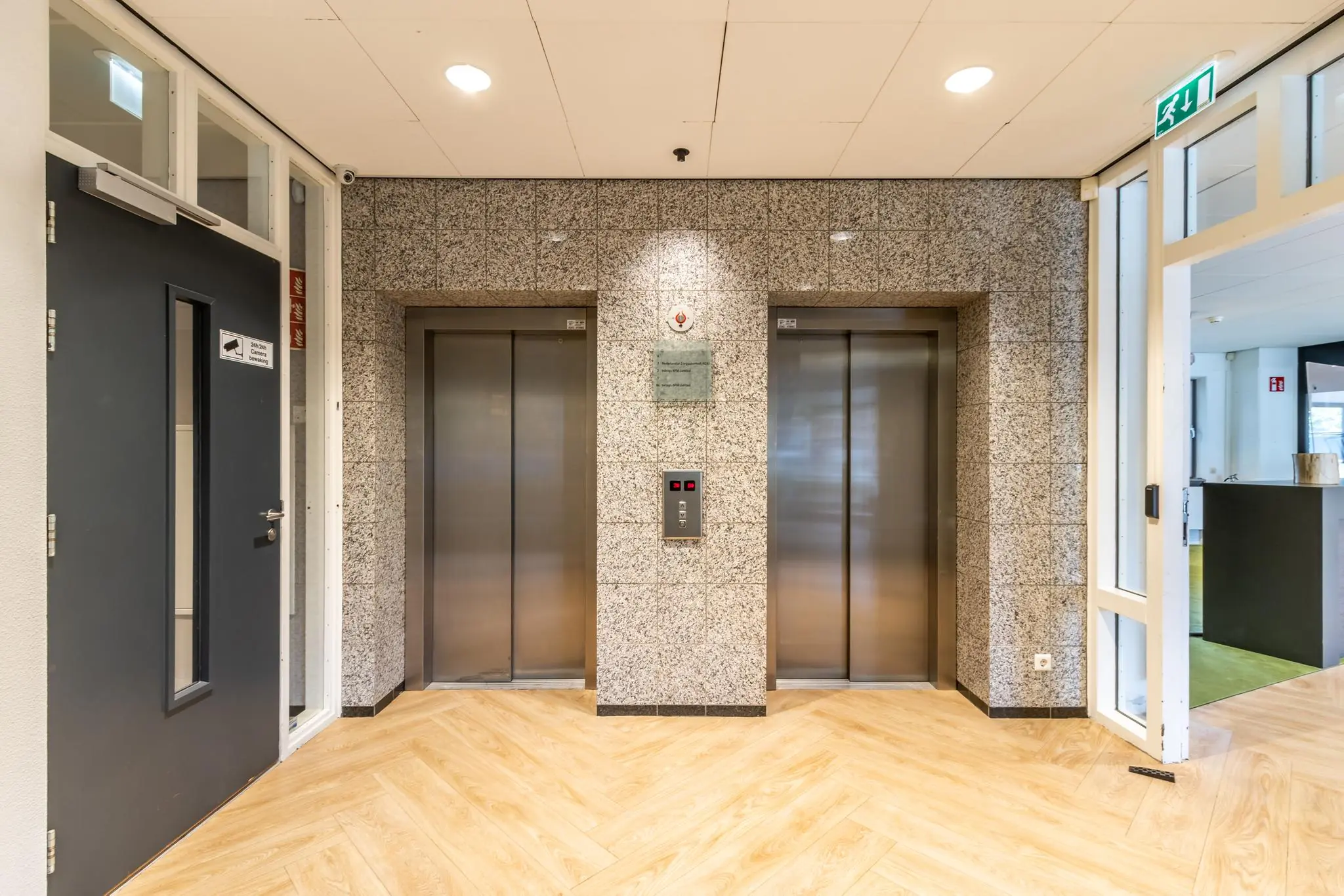 Ingang met twee liften in de centrale hal van een kantoorgebouw aan de Pythagoraslaan.