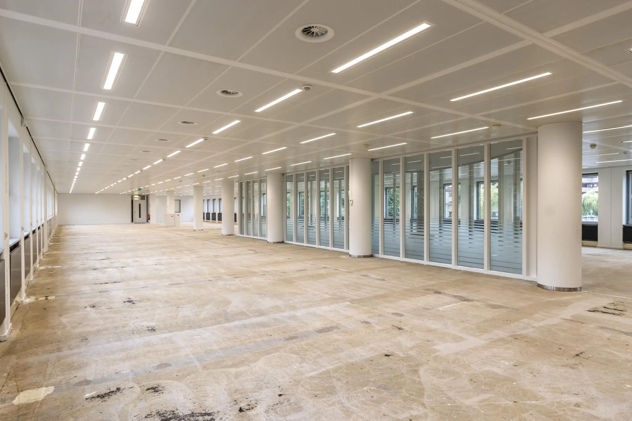Leeg en gerenoveerd kantoorpand aan de Pythagoraslaan met systeemplafond en glazen scheidingswanden.