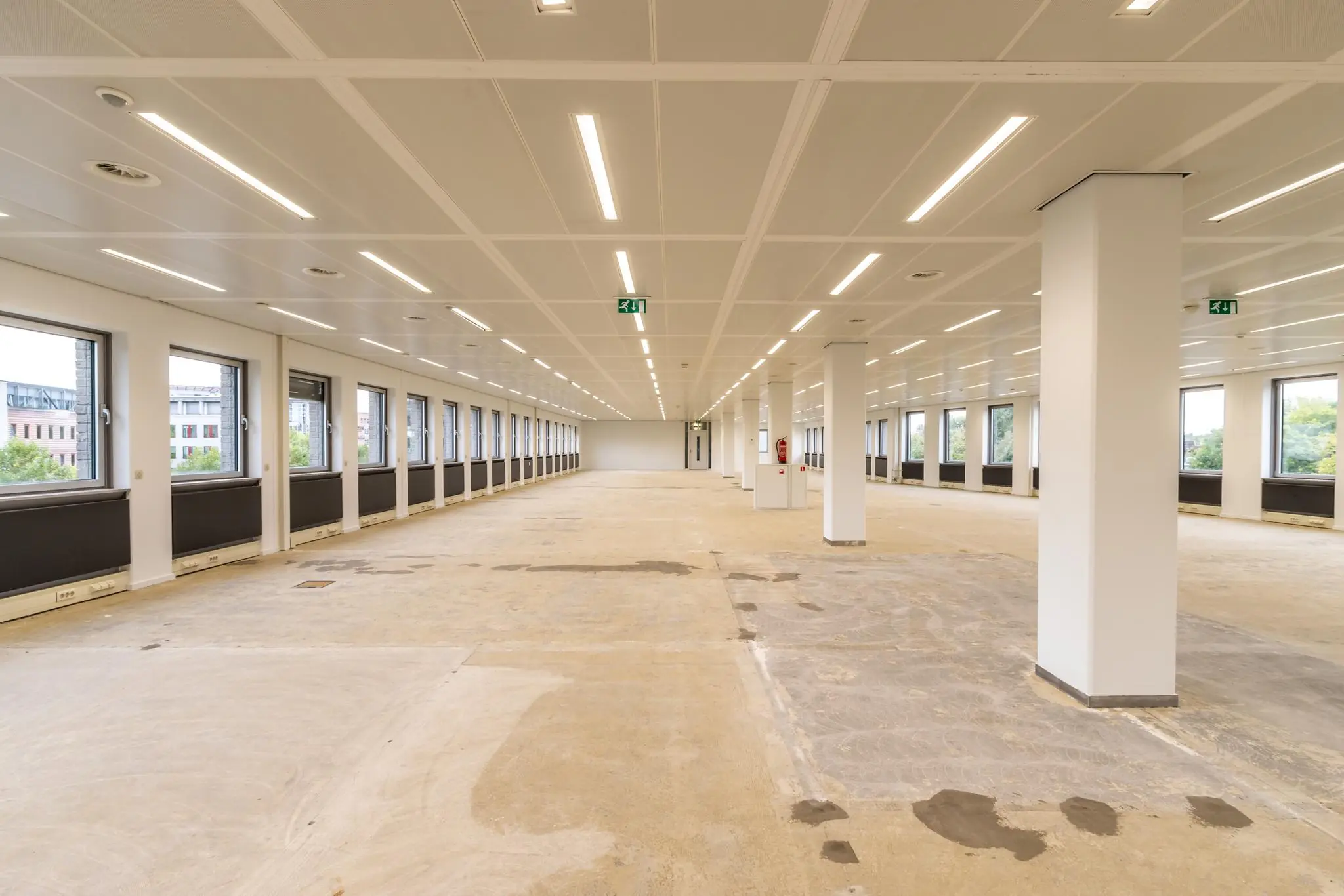 Leegstaande en gerenoveerde kantoorruimte aan de Pythagoraslaan met veel ramen en strakke plafondverlichting.