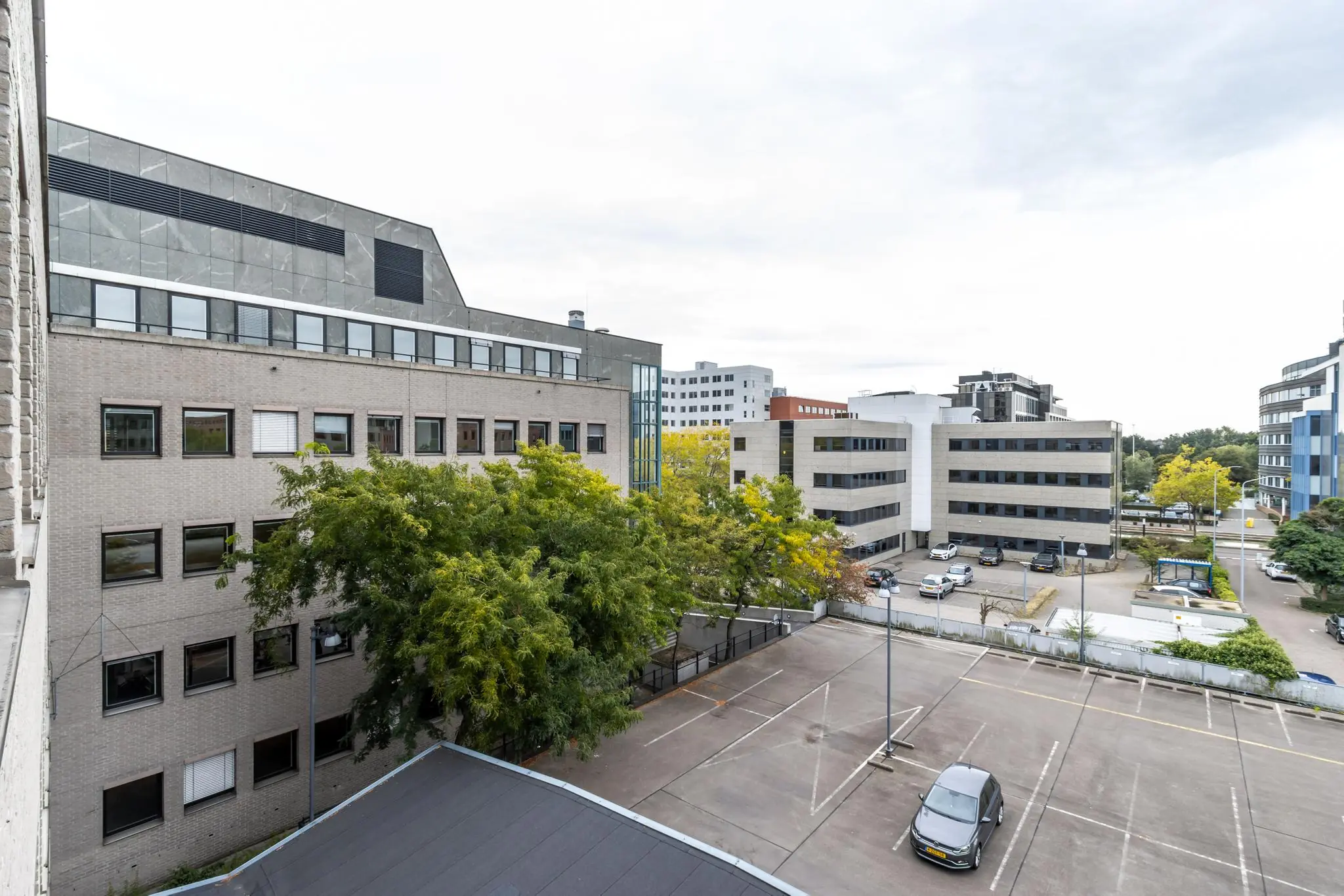 Kantoorgebouwen aan de Pythagoraslaan in Utrecht met een deels leeg parkeerterrein op de voorgrond.