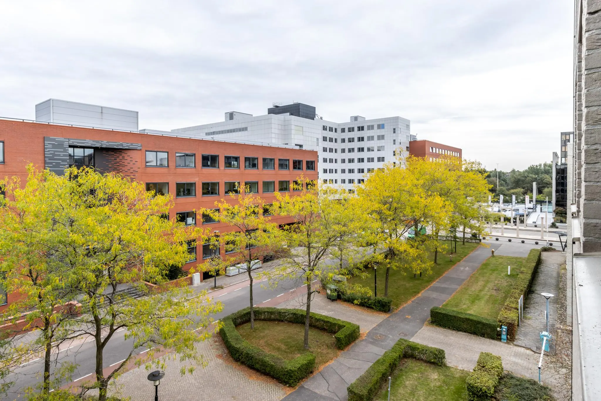 Kantoor- en bedrijfsgebouwen aan de Pythagoraslaan in Utrecht met bomen en wandelpaden in de groene omgeving.