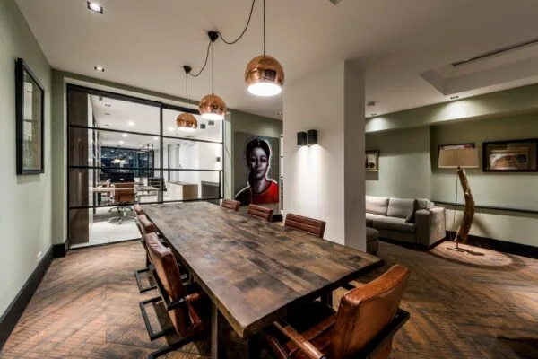 Stijlvol ingericht vergaderruimte aan de Emmastraat met houten tafel, leren stoelen en moderne verlichting.