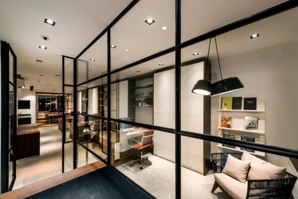 Modern kantoorinterieur aan de Emmastraat met glazen wanden, strakke werkplekken en warme verlichting.