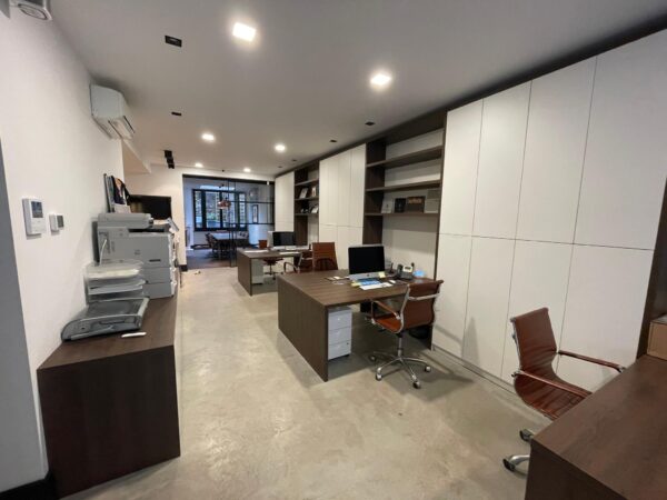 Modern ingericht kantoor aan de Emmastraat met houten bureaus, kastenwand en open werkruimte.