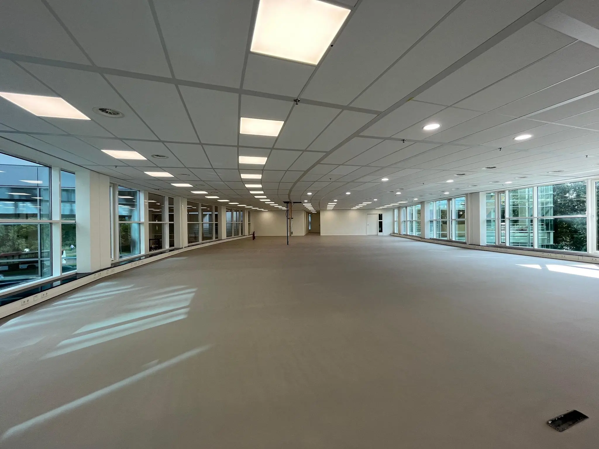 Leeg, modern kantoorpand aan de Newtonlaan met grote ramen en systeemplafond.