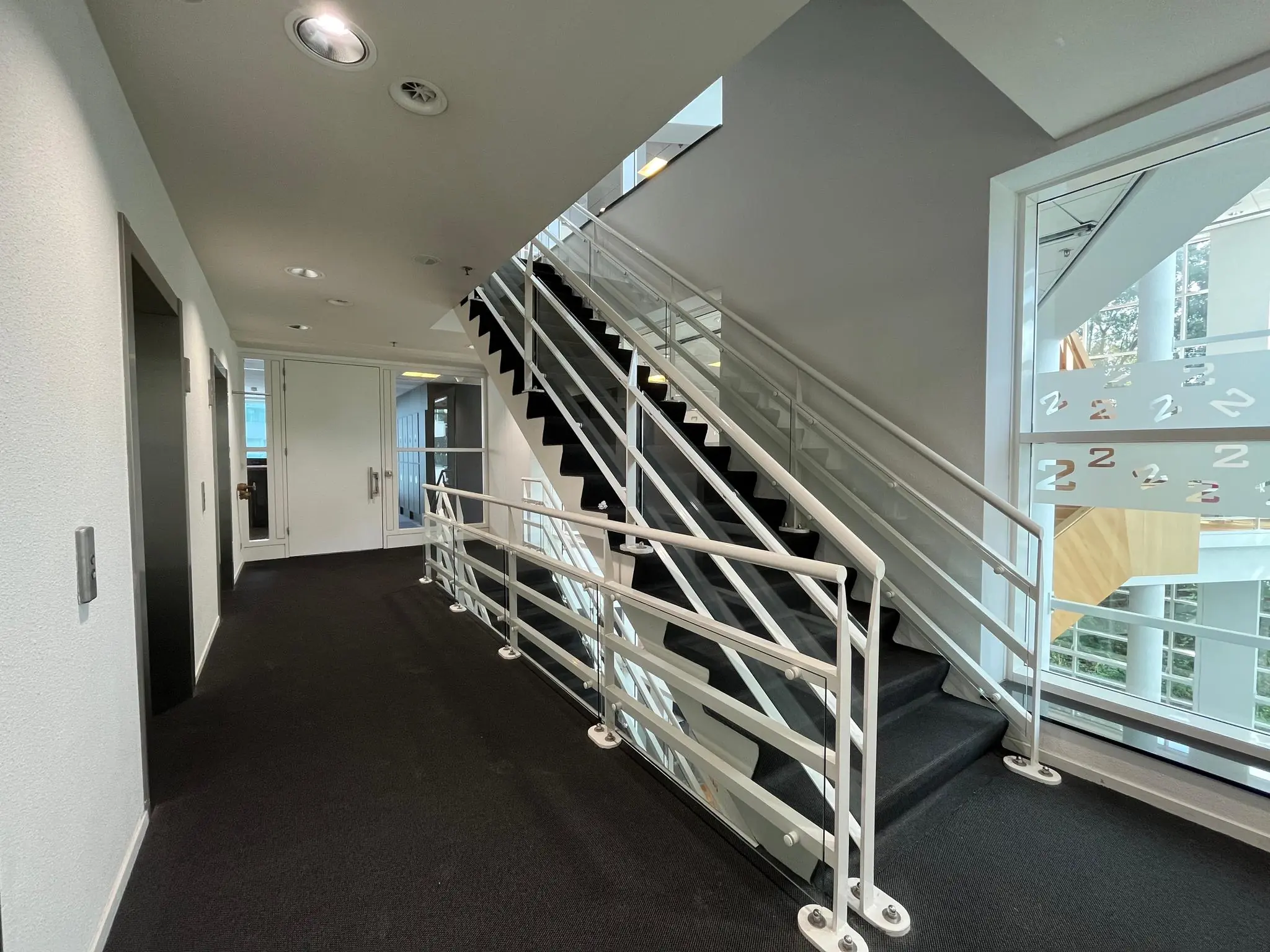 Moderne kantoorhal met trap en lift in het Newtonlaan-gebouw.