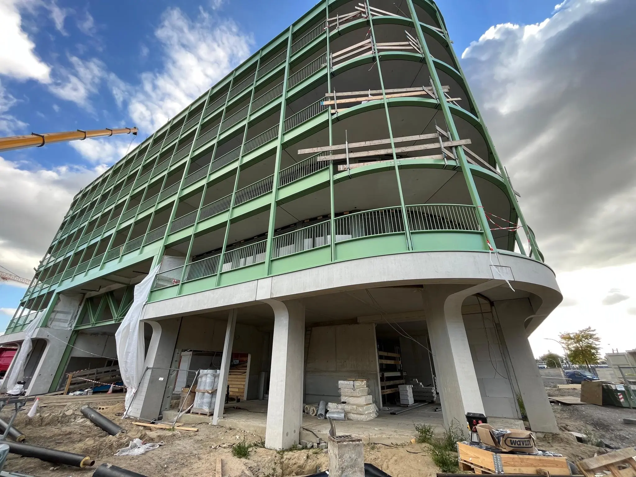 Gebouw in aanbouw aan de Cartesiusweg met groene gevel en ronde hoeken.